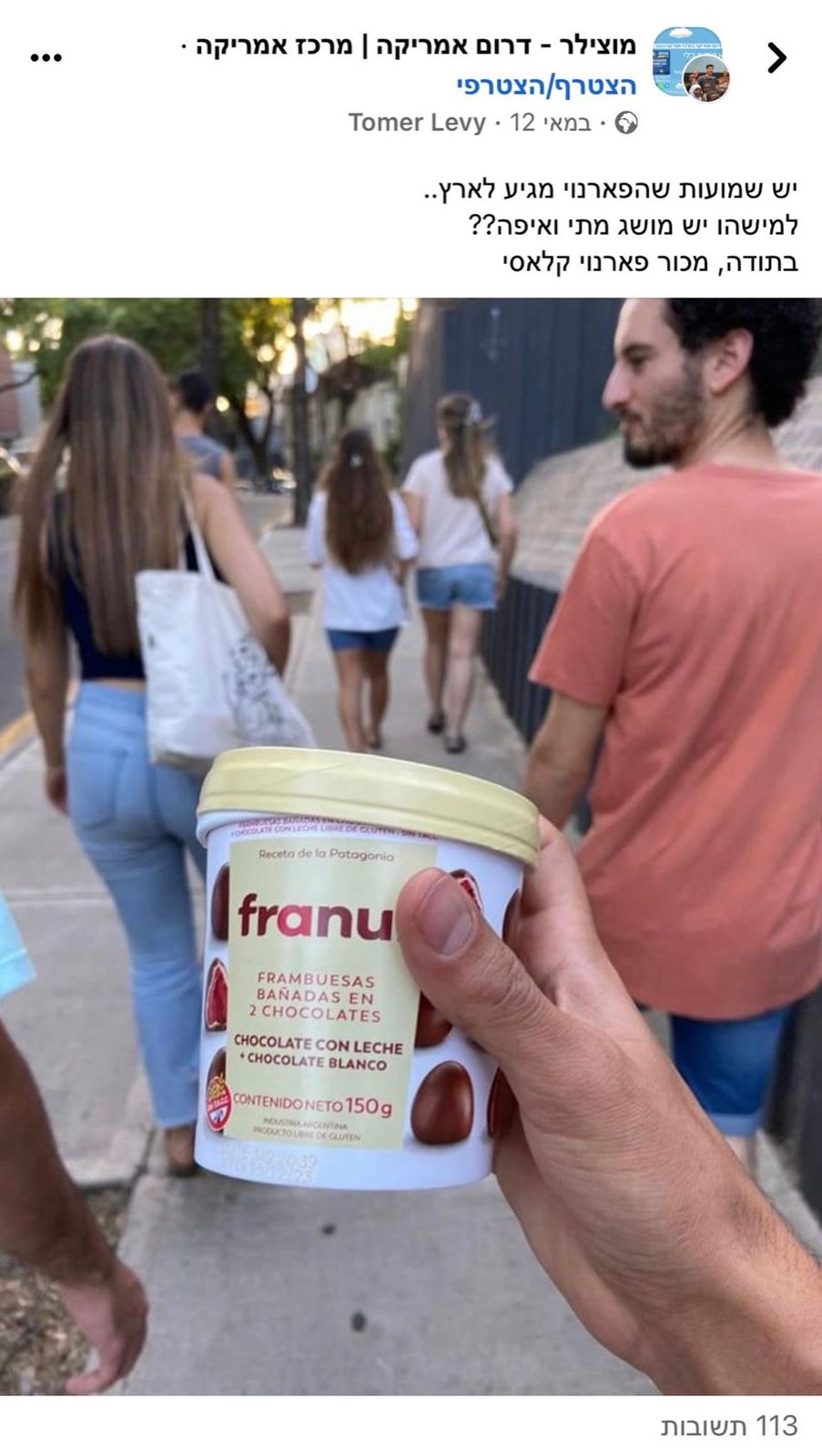 גביע פרנואי מוחזק ביד ברחוב בעיר, ועל המכסה פטל טרי ופטל בציפוי שוקולד